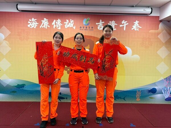 三位海巡同仁手持春聯作品，展現新春喜氣與廉政文化氛圍