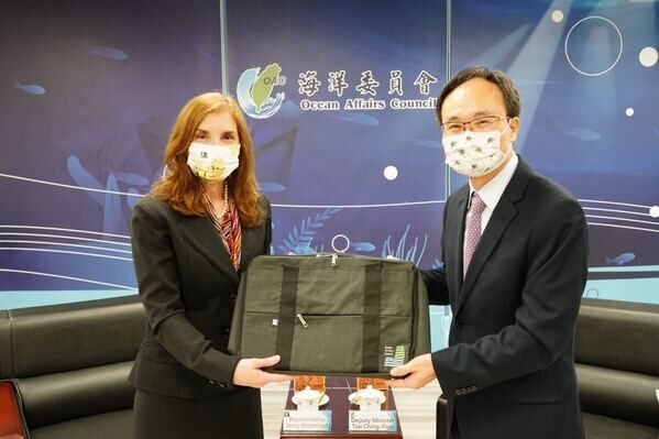 Deputy Minister Tsai (right) presents a briefcase made of waste fishing nets to Representative Bloomfield (left).