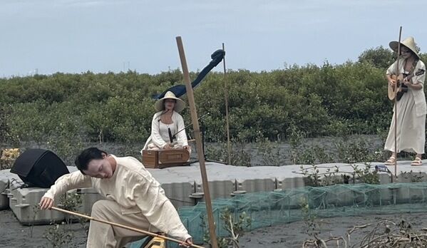 潮間帶的背景下，人劇團音樂與舞蹈結合演出呈現出一幅美麗的畫作